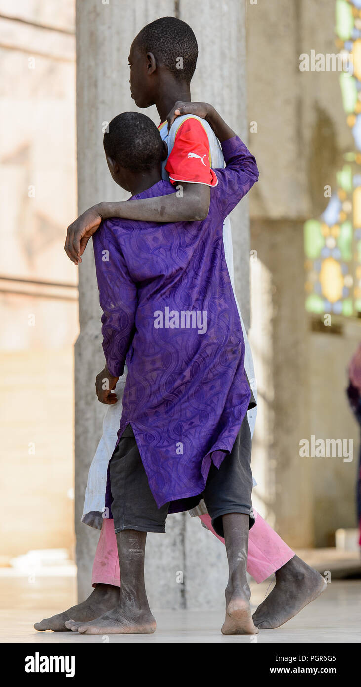 TOUBA, SÉNÉGAL - 26 avr 2017 : garçons sénégalais non identifiés en vêtements traditionnels à pied dans la Grande Mosquée de Touba, l'accueil de la confrérie Mouride Brotherh Banque D'Images
