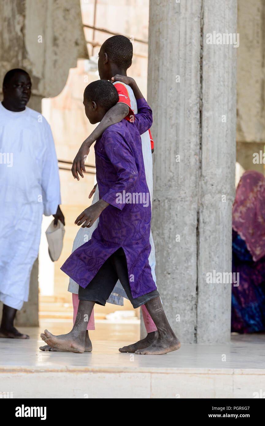 TOUBA, SÉNÉGAL - 26 avr 2017 : garçons sénégalais non identifiés en vêtements traditionnels à pied dans la Grande Mosquée de Touba, l'accueil de la confrérie Mouride Brotherh Banque D'Images