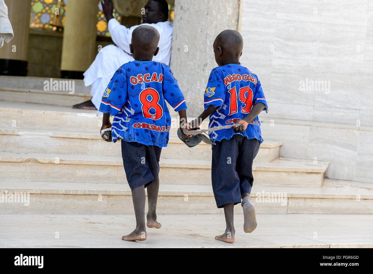 TOUBA, SÉNÉGAL - 26 avr 2017 : garçons sénégalais non identifiés en sportwear à pied dans la Grande Mosquée de Touba, l'accueil de la confrérie Mouride Banque D'Images