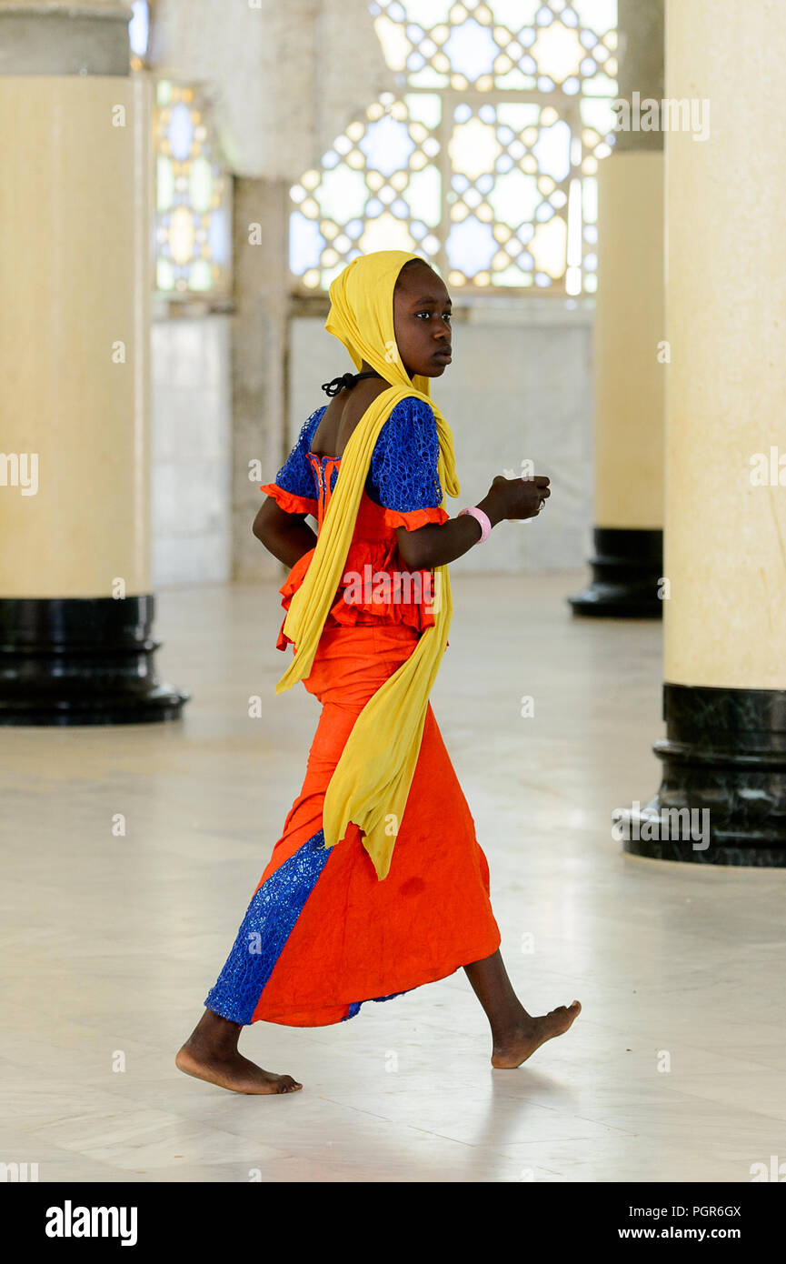 TOUBA, SÉNÉGAL - 26 avr 2017 : femme sénégalaise non identifiés en vêtements traditionnels colorés et voile promenades dans la Grande Mosquée de Touba, l'accueil Banque D'Images