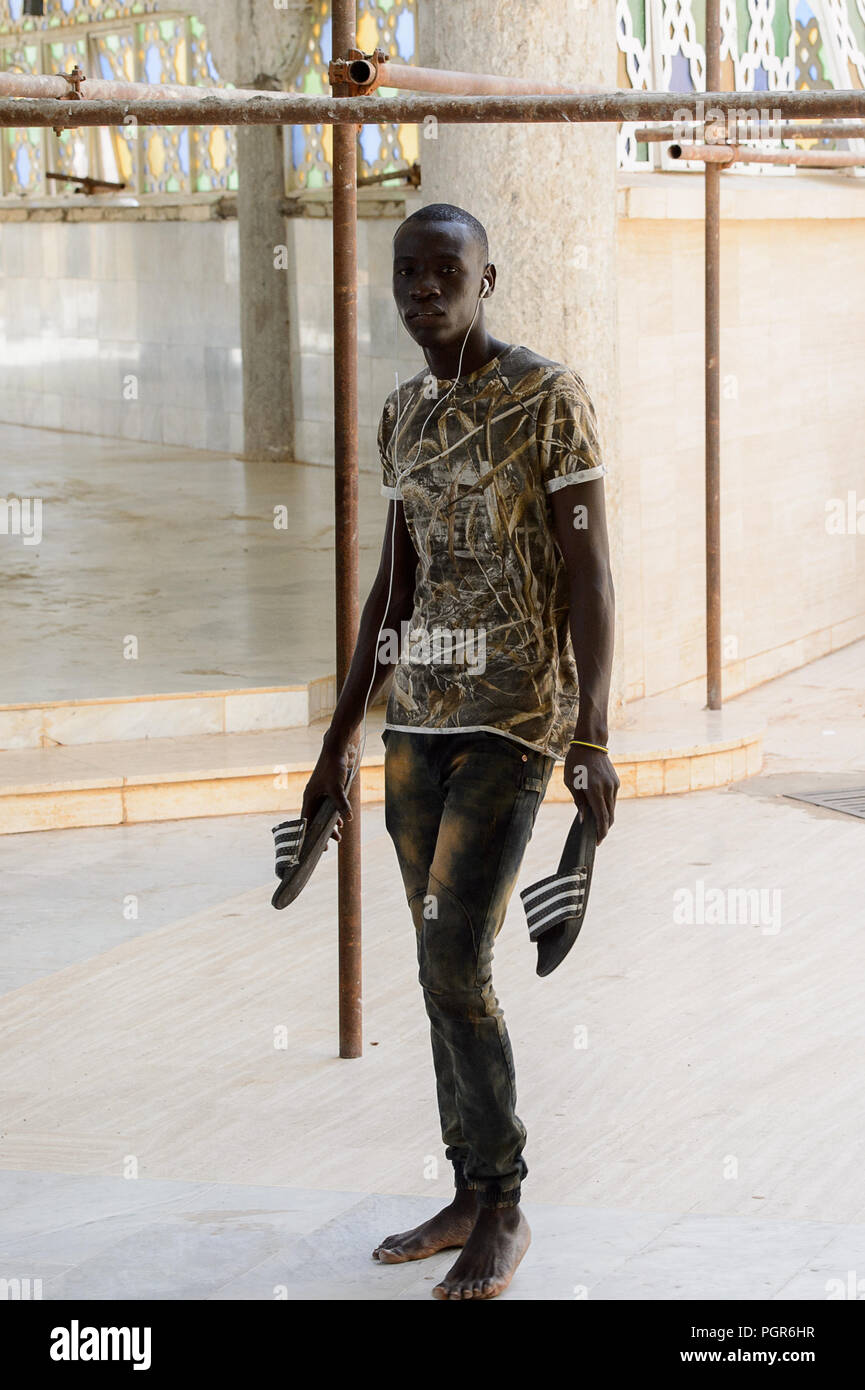TOUBA, SÉNÉGAL - Apr 26, 2017 : l'homme aux pieds nus sénégalais non identifiés à l'écoute de la musique dans la Grande Mosquée de Touba, l'accueil de la confrérie Mouride Banque D'Images
