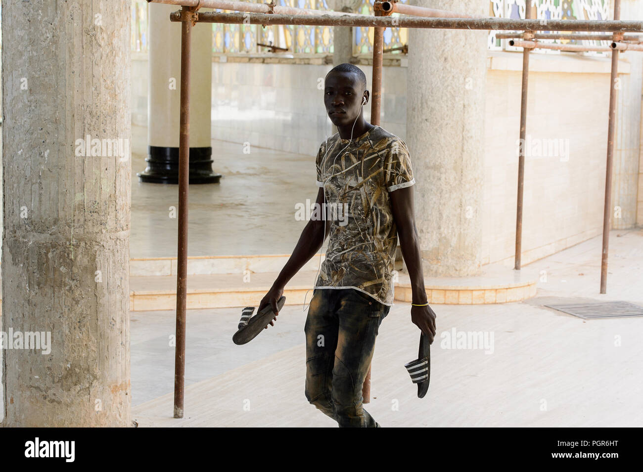 TOUBA, SÉNÉGAL - Apr 26, 2017 : l'homme aux pieds nus sénégalais non identifiés à l'écoute de la musique dans la Grande Mosquée de Touba, l'accueil de la confrérie Mouride Banque D'Images