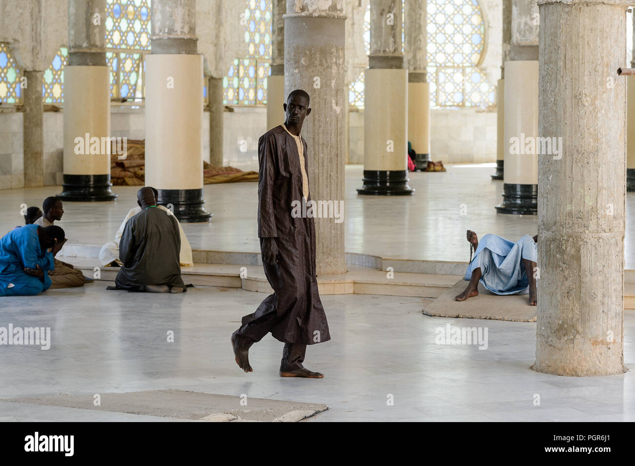 TOUBA, SÉNÉGAL - Apr 26, 2017 : l'homme aux pieds nus sénégalais non identifiés en vêtements traditionnels promenades dans la Grande Mosquée de Touba, l'accueil de la confrérie Mouride Banque D'Images