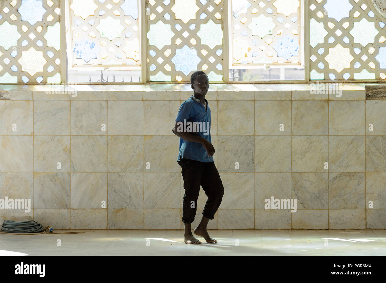 TOUBA, SÉNÉGAL - 26 avr 2017 : homme marche pieds nus sénégalais non identifiés dans la Grande Mosquée de Touba, l'accueil de la confrérie Mouride Banque D'Images