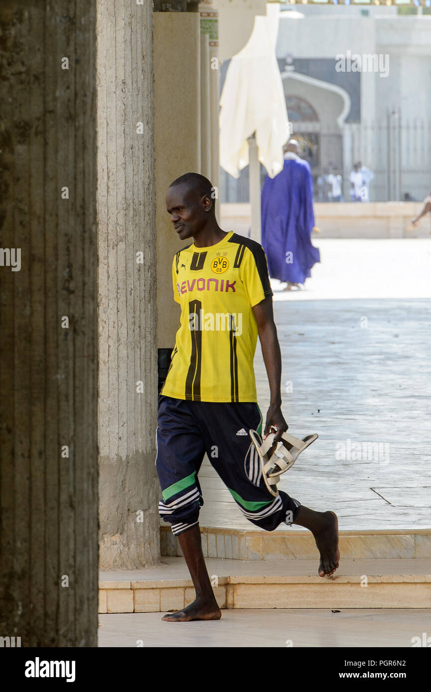 TOUBA, SÉNÉGAL - 26 avr 2017 : homme marche pieds nus sénégalais non identifiés dans la Grande Mosquée de Touba, l'accueil de la confrérie Mouride Banque D'Images