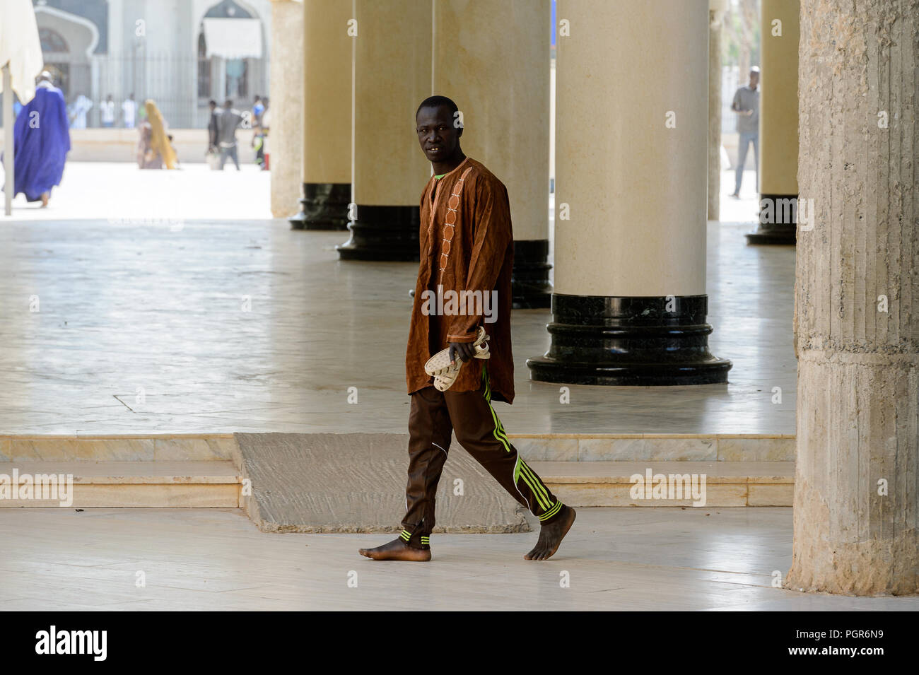 TOUBA, SÉNÉGAL - 26 avr 2017 : homme marche pieds nus sénégalais non identifiés dans la Grande Mosquée de Touba, l'accueil de la confrérie Mouride Banque D'Images