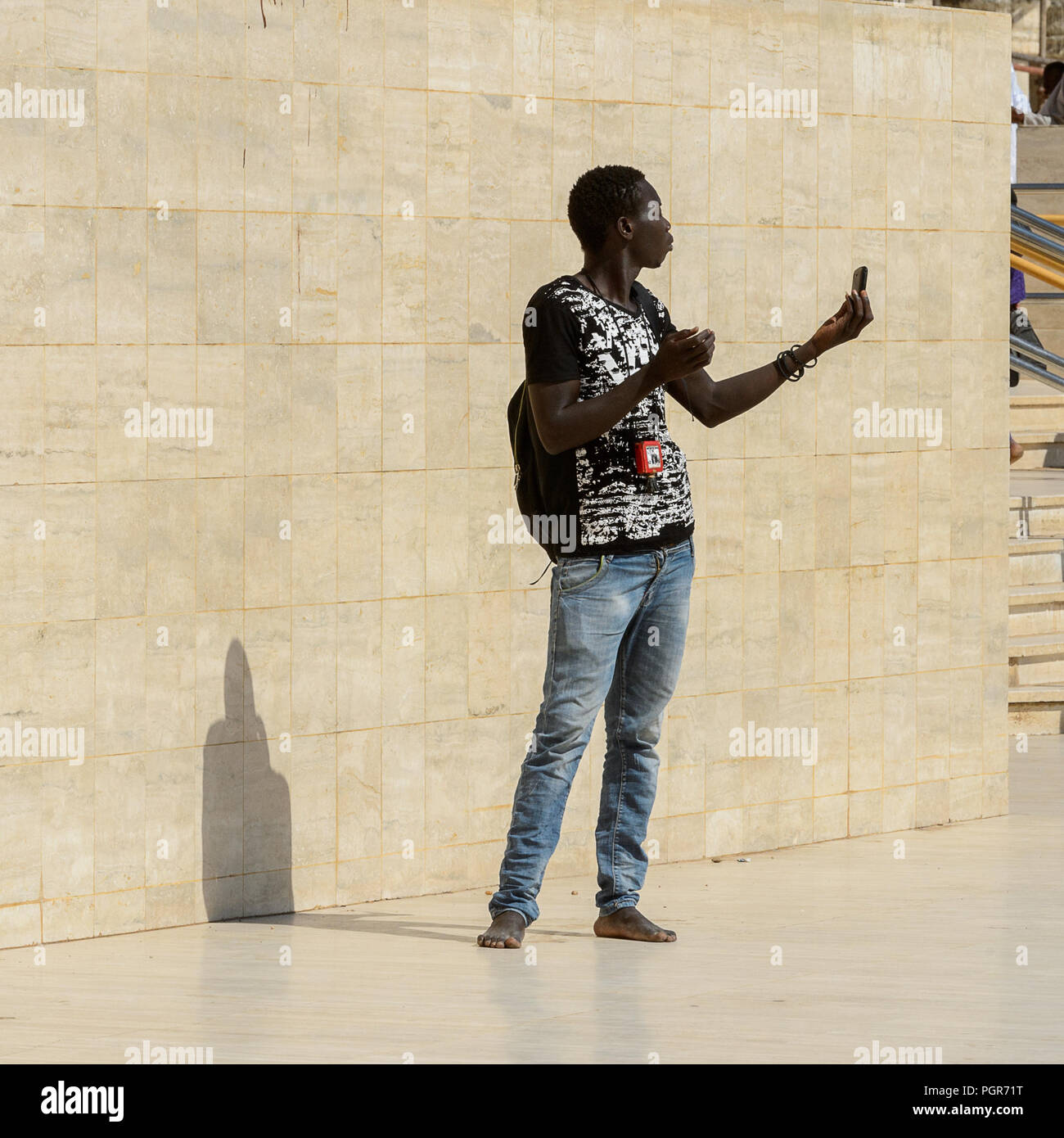 TOUBA, SÉNÉGAL - Apr 26, 2017 : l'homme sénégalais non identifiés se tient près du mur de la Grande Mosquée de Touba, l'accueil de la confrérie Mouride Banque D'Images