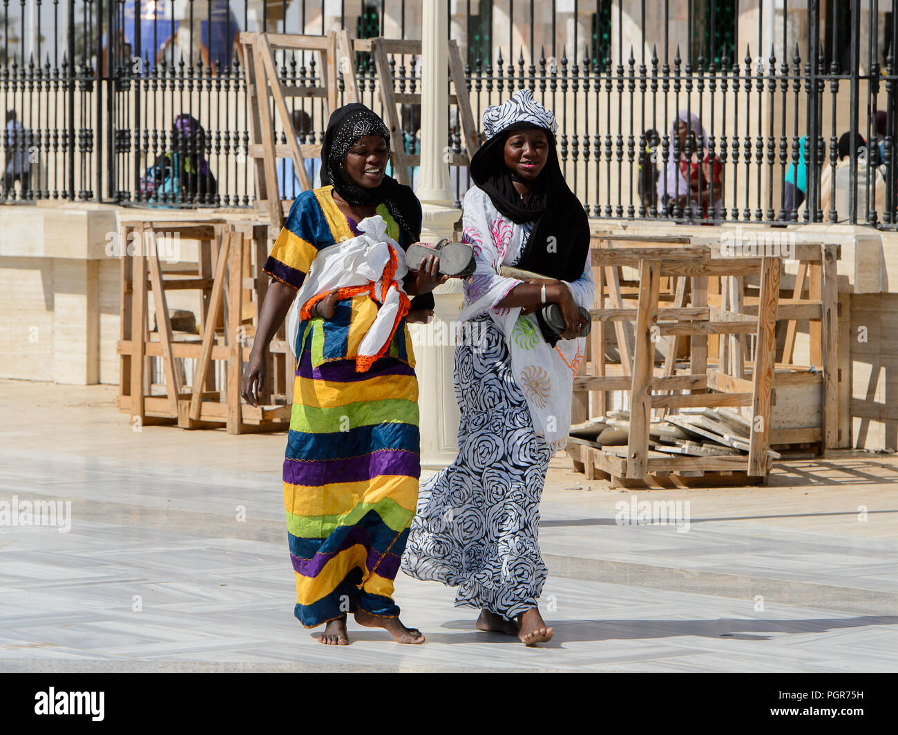 TOUBA, SÉNÉGAL - 26 avr 2017 non identifié : la femme sénégalaise en vêtements traditionnels colorés à pied dans la Grande Mosquée de Touba, l'accueil de la confrérie Mouride Banque D'Images