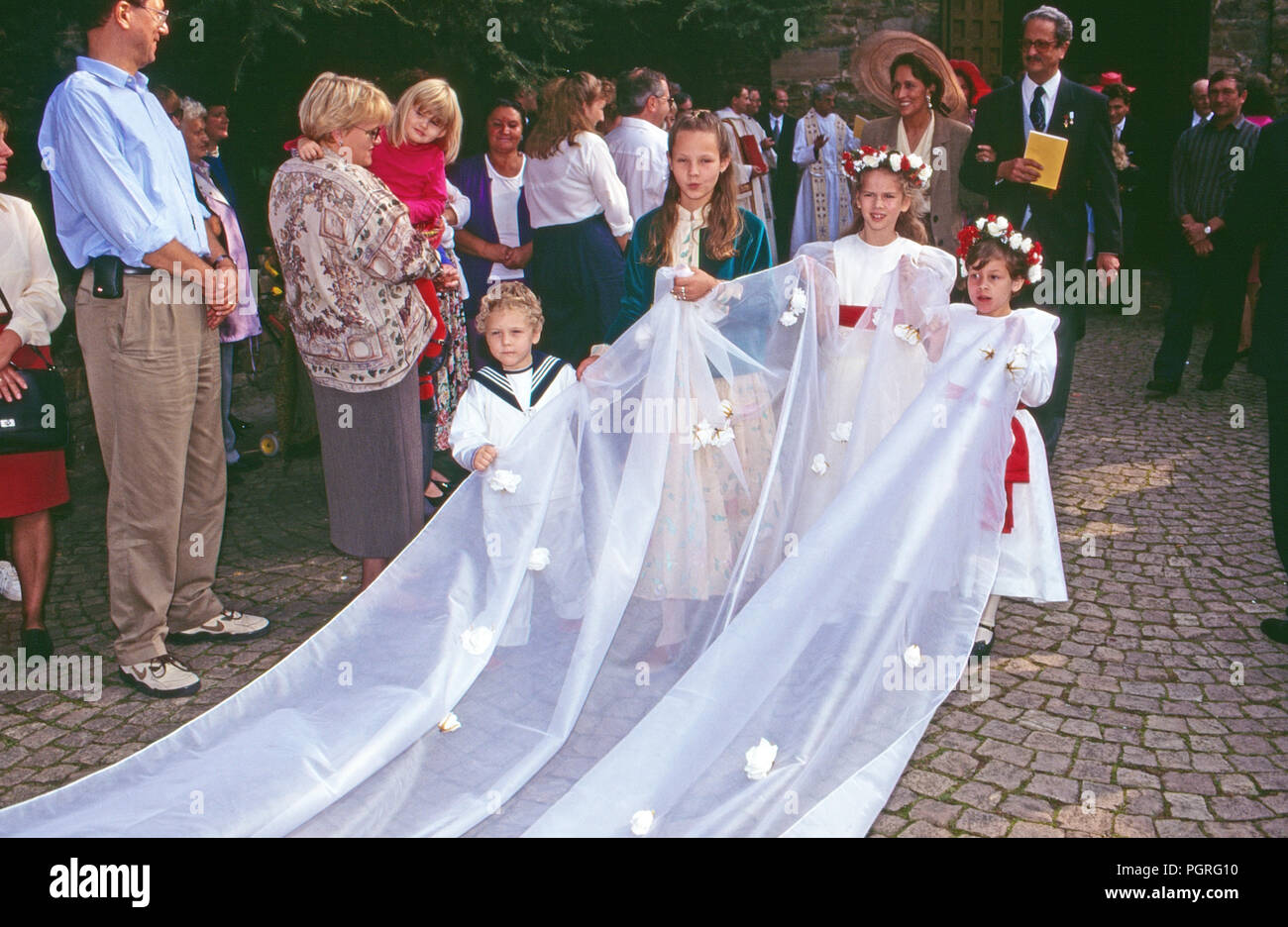 Kinder tragen den Brautschleier bei der Hochzeit von Andreas Augst von Habsburg Lothringen mit Maria Christina von Hatzfeld Dönhoff dans Mondorfstraße, Deutschland 1994. Des enfants portant le voile de la mariée au mariage d'Andreas August de Habsbourg Lorraine avec Maria Christine de Hatzfeld Doenhoff à Johannisberg, Allemagne 1994. Banque D'Images