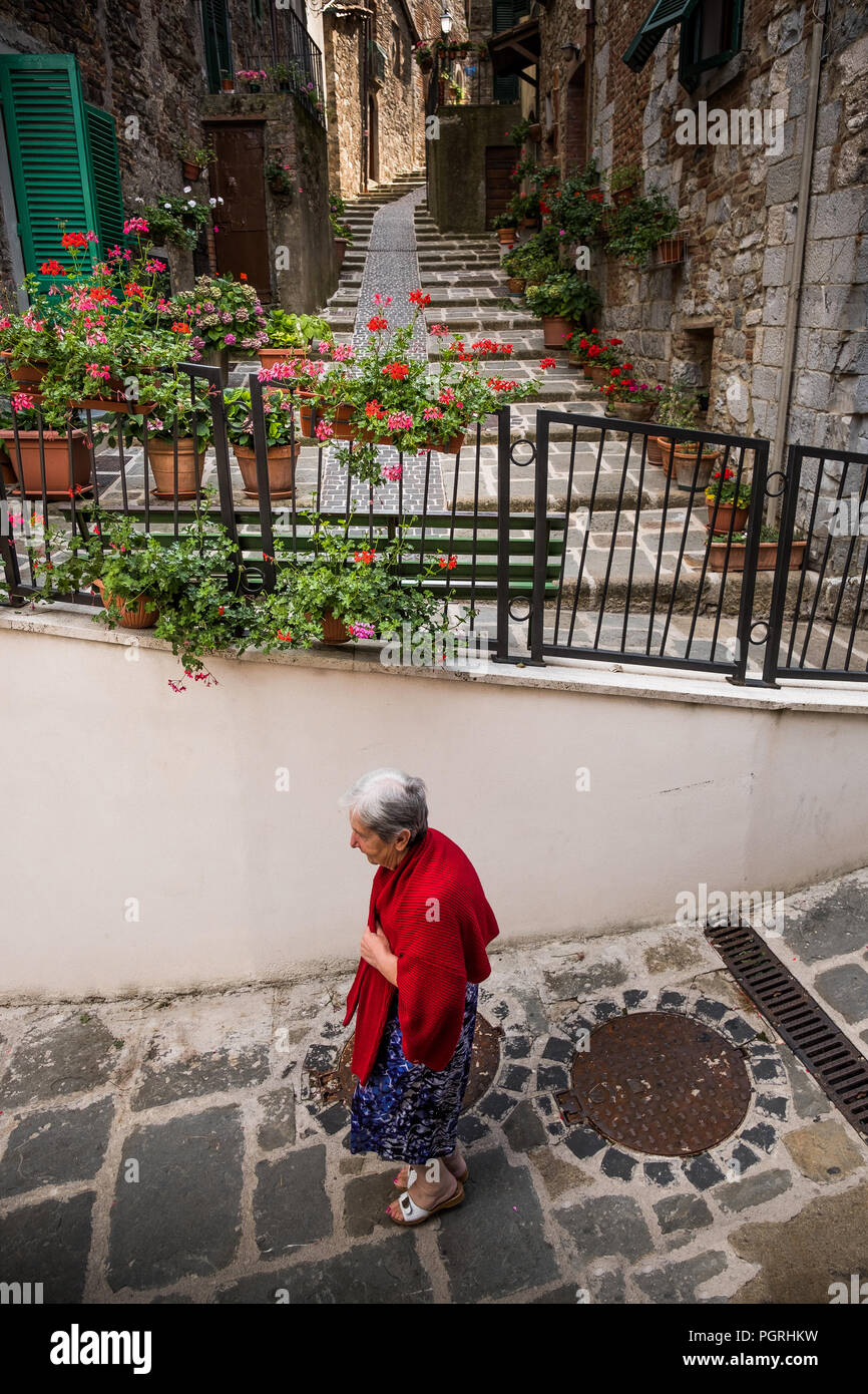 Follonica, Grosseto, Toscane - village ancien, pas de femme marche sur des petites ruelles typiques et des bâtiments en pierre Banque D'Images