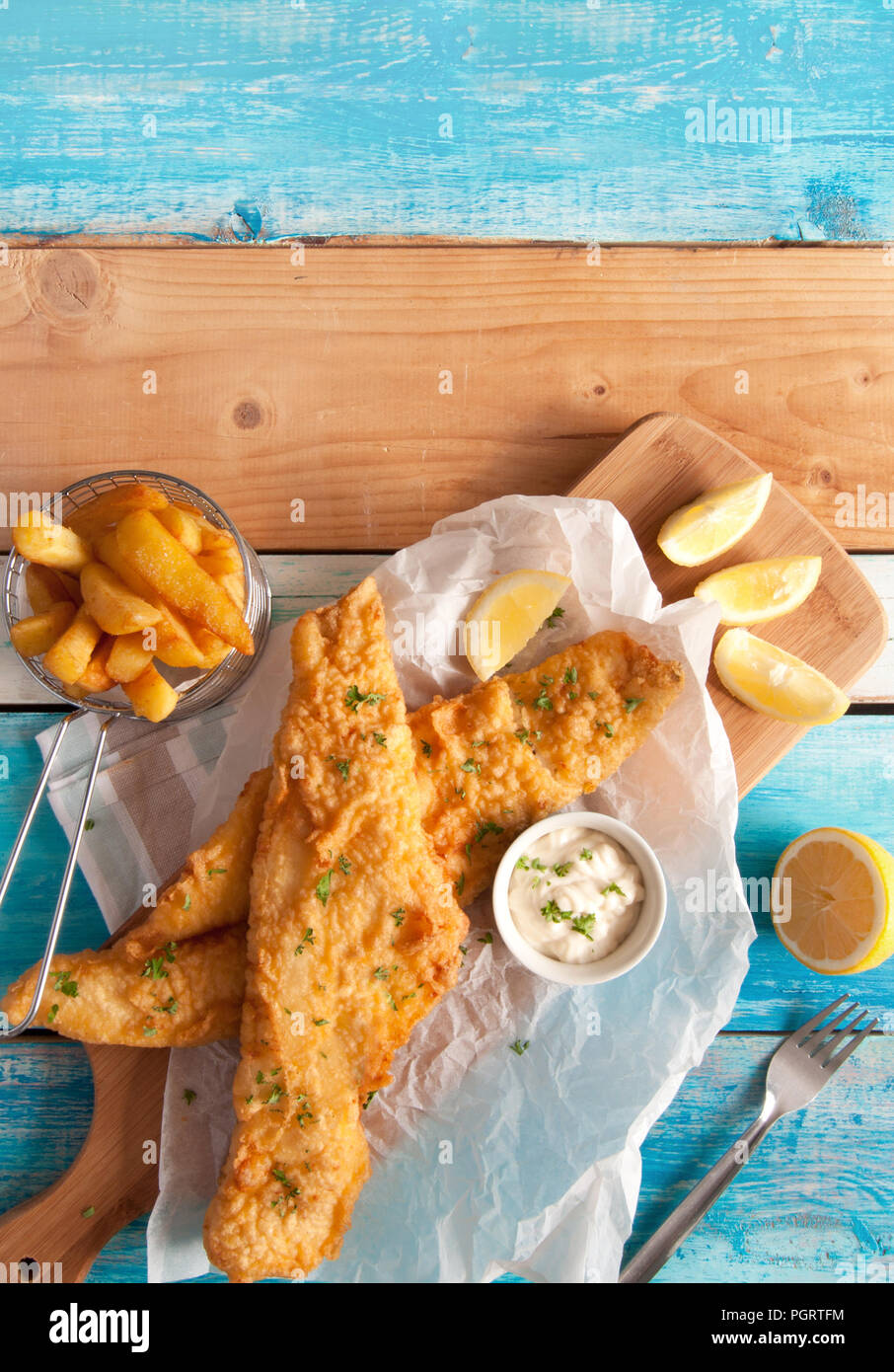 Deux morceaux de poisson frit dans la pâte avec des jetons dans un panier Banque D'Images