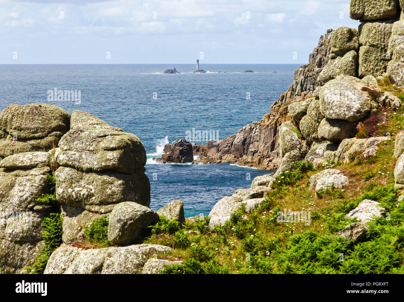 Le phare de Drakkars vu à travers les rochers à Roskestal Falaise près de Land's End, Cornwall, England, UK Banque D'Images