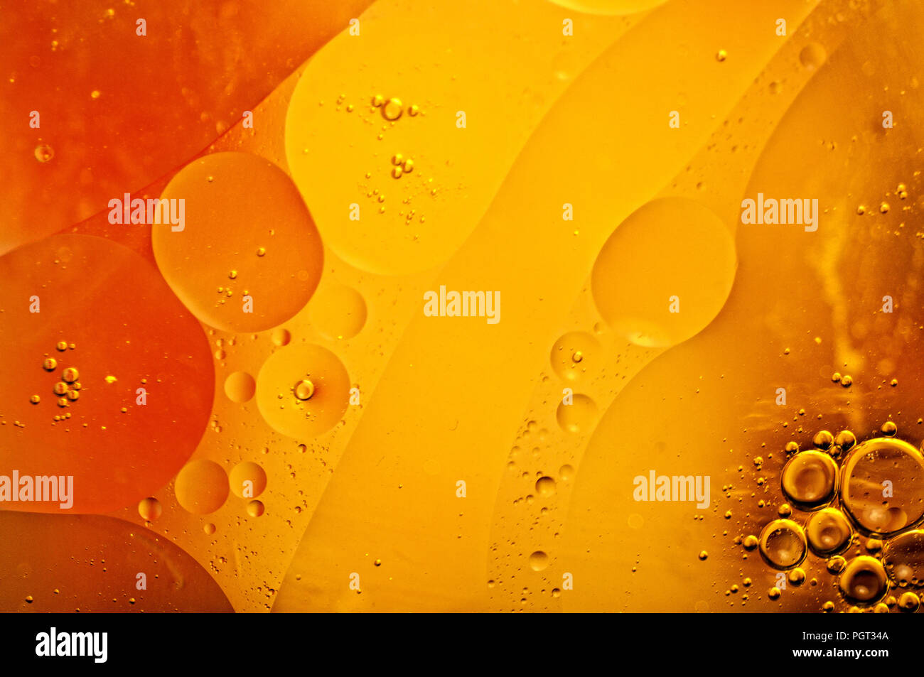 Résumé de l'huile d'olive flottant sur l'eau avec du jaune, orange et les couleurs. Banque D'Images