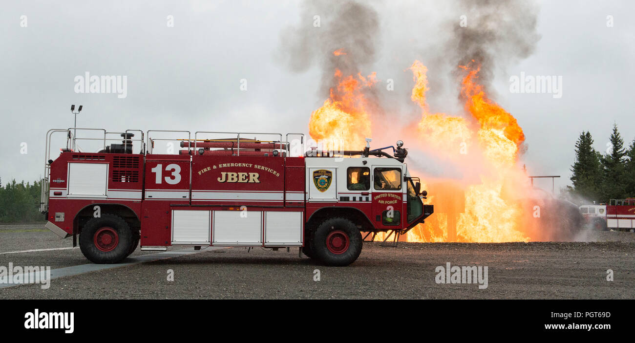 U.S. Air Force Protection incendie spécialistes chargés de la 673e Escadron d'Ingénieur Civil, pulvériser de l'eau de leur sauvetage et de lutte contre les incendies d'aéronefs gâche véhicule tout en répondant à une simulation d'incendie d'aéronefs de guerre au cours de formation à la préparation à la lutte contre les incendies-Joint Base Elmendorf-Richardson, Alaska, le 23 août, 2018. Au cours de la formation de préparation à l'Armée de l'air les pompiers ont enfilé divers niveaux de protection axé sur la mission de posture (MOPP) et pratiqué répondant aux situations d'urgence à une simulation d'environnement toxique lors d'un incident chimique, biologique, radiologique ou nucléaire grève. (U.S. F Air Banque D'Images