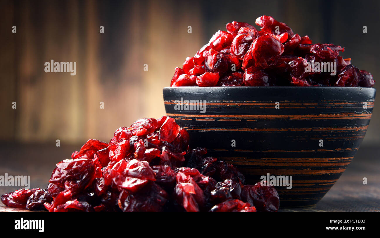 La composition avec bol de canneberges séchées sur table en bois. Banque D'Images