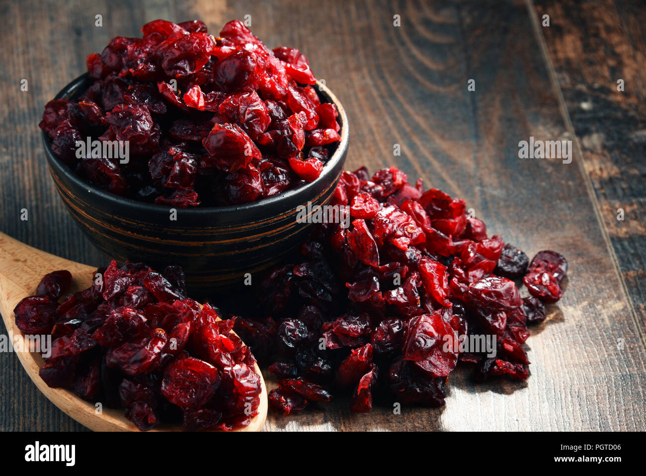 La composition avec bol de canneberges séchées sur table en bois. Banque D'Images