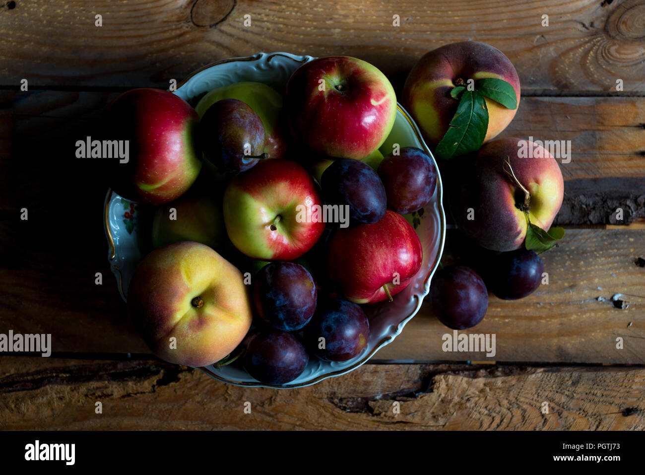 Jardin des fruits d'été dans un bol sur une table en bois, vue du dessus Banque D'Images