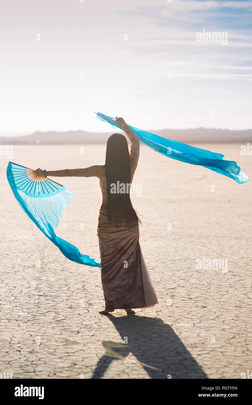 Danseuse dans le désert avec des tissus de soie Banque D'Images