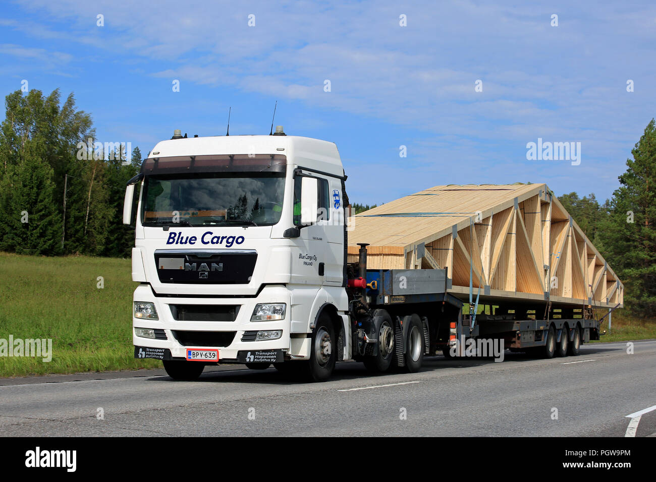 UURAINEN, FINLANDE - le 25 août 2018 : White MAN TGX 26,480 semi truck de Blue Cargo Oy charpente transporte sur une remorque le long de la route. Banque D'Images