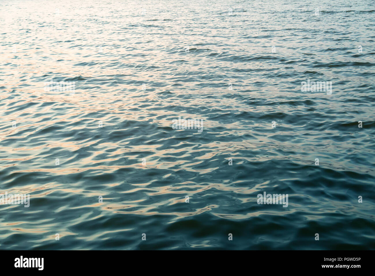 La surface de l'eau bleu foncé avec redlection la lumière au coucher du soleil. Fond de l'eau de mer ou l'océan. Banque D'Images
