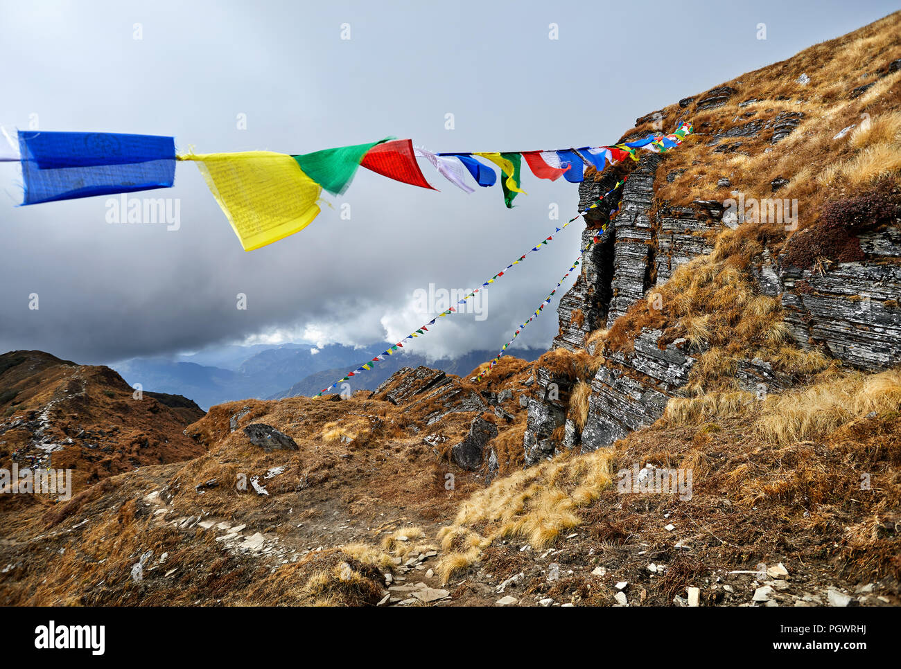 Les rochers et les drapeaux de prière Tibetains Lung Ta au camp de base à l'Himal Mardi Nuageux sommets de montagnes de l'Himalaya au Népal Banque D'Images