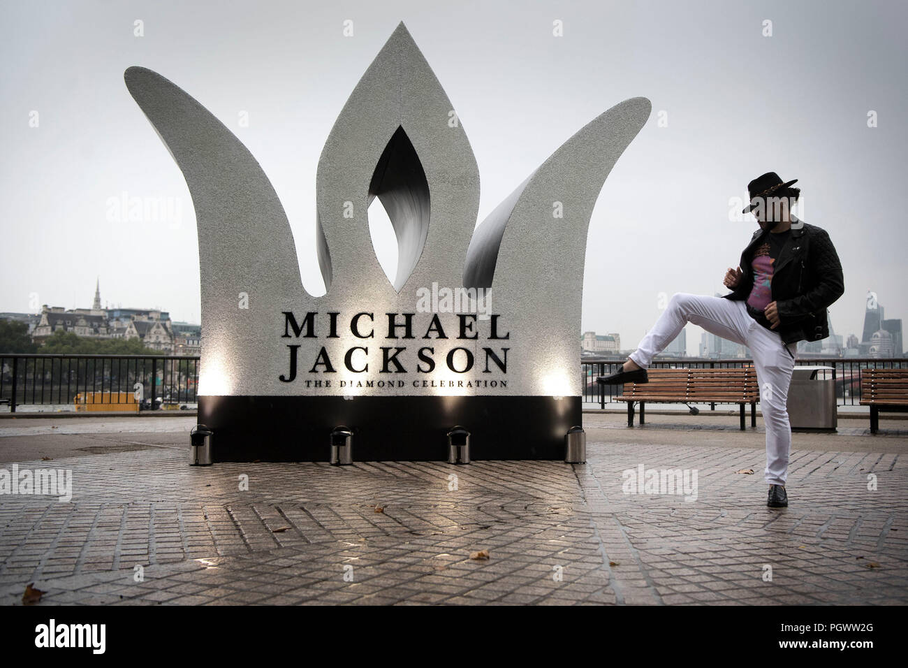 Une fan de Michael Jackson pose avec un 13 pieds de haut de la couronne de joyaux qui a été installé sur la rive sud de Londres pour marquer ce qui aurait été Michael Jackson l'âge de 60 ans. Banque D'Images