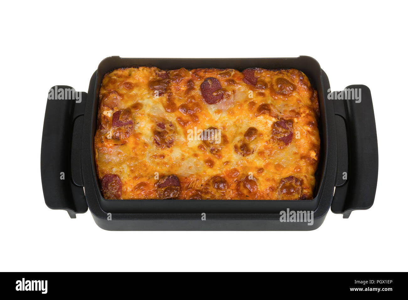 Des pizzas au salami, bacon, sauce tomate, mozzarella, fromage jaune dans un plat de cuisson carré isolé sur fond blanc. Banque D'Images