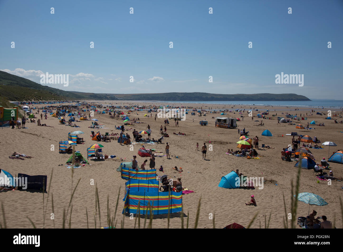 Les personnes bénéficiant d'un jour d'été sur la plage de Woolacombe, Devon, Angleterre, ciel bleu et une grande plage de sable avec beaucoup de gens ayant une belle journée Banque D'Images