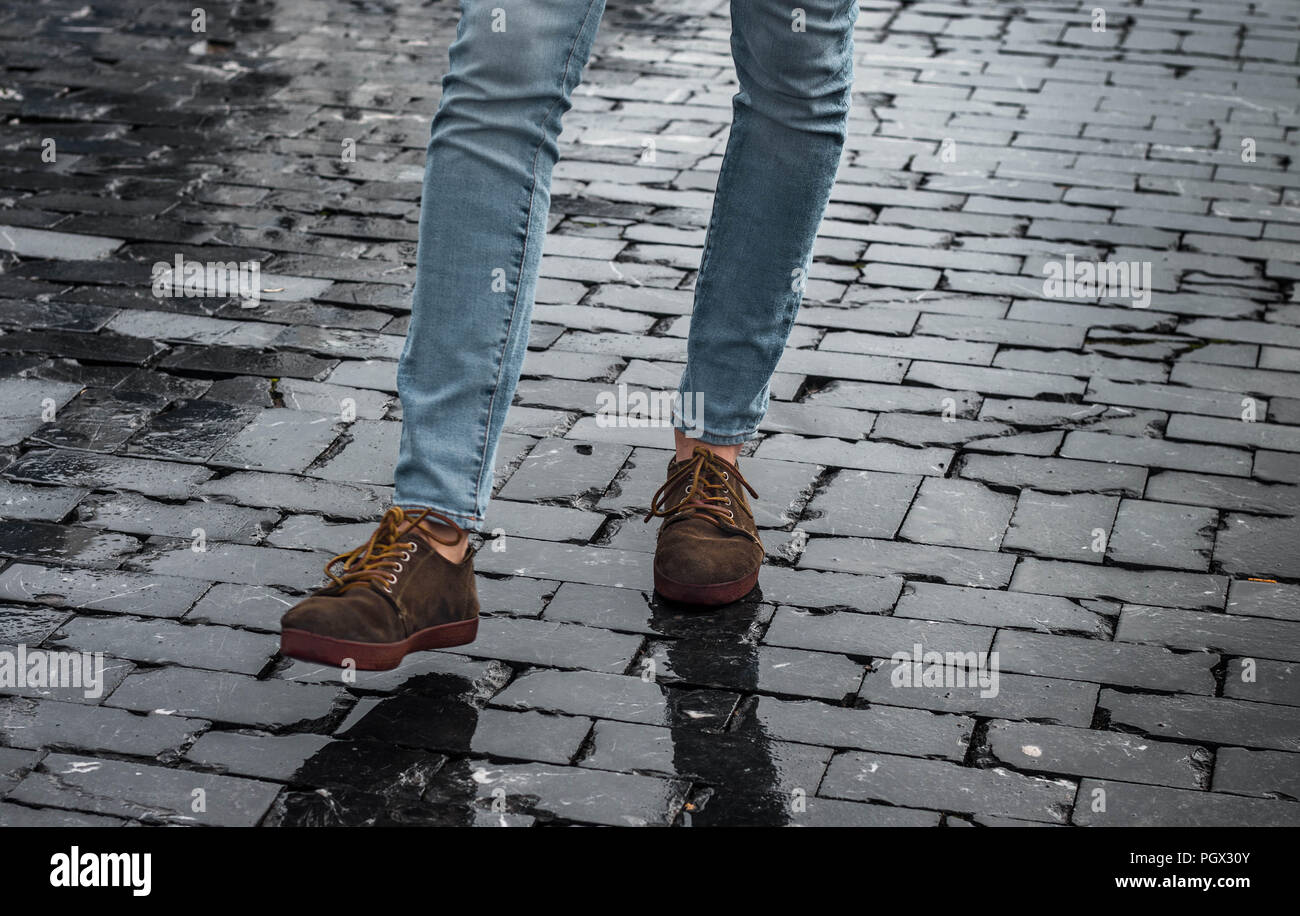 Chaussures homme hipster marron et les jambes au niveau de la rue avec des  briques noires prenant un pas Photo Stock - Alamy
