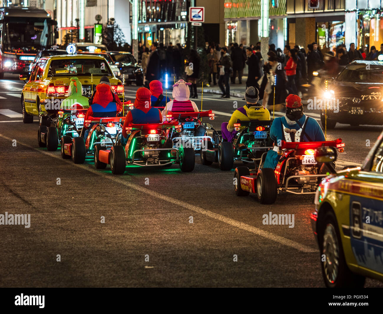 Super Mario Karts Tokyo - Touristes en voiture du vrai Super Mario Karts ( Super Karts Wario ) à travers le trafic de Tokyo au crépuscule Banque D'Images