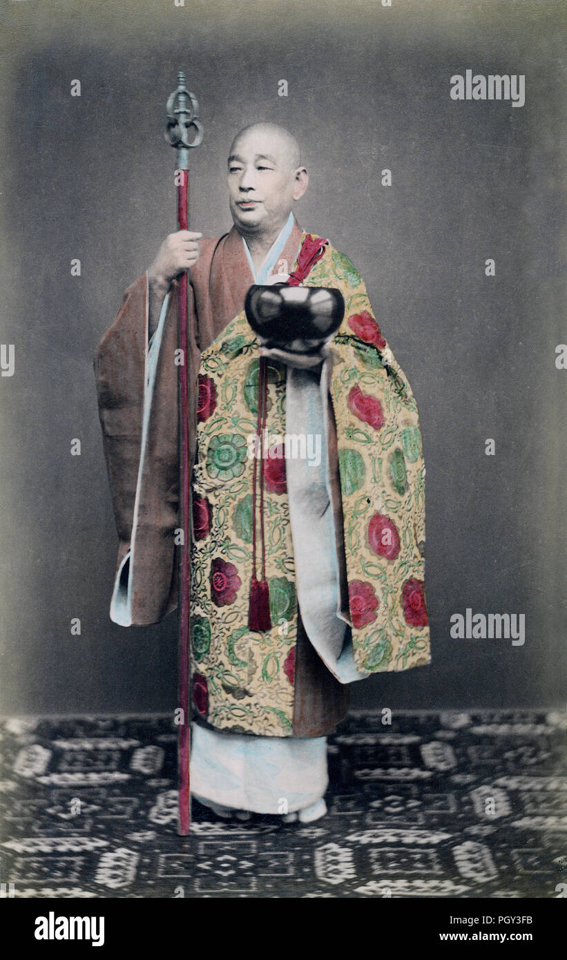 [ 1890 Japon - Priest bouddhiste japonais ] — ce prêtre bouddhiste tient un bol de mendicité et un étaf. Il porte un tole de moine, appelé kesa, fait de somptueux brocart de soie. Les kesa sont drapés sur une épaule et sous le bras opposé afin de l'enrouler autour du corps. On croit qu'ils ressemblent à un vêtement fait pour Bouddha par sa mère. D'une forme simple rectangulaire, ils ont à peine changé depuis l'introduction du bouddhisme au Japon au cours du sixième siècle. photographie d'albumine vintage du xixe siècle. Banque D'Images
