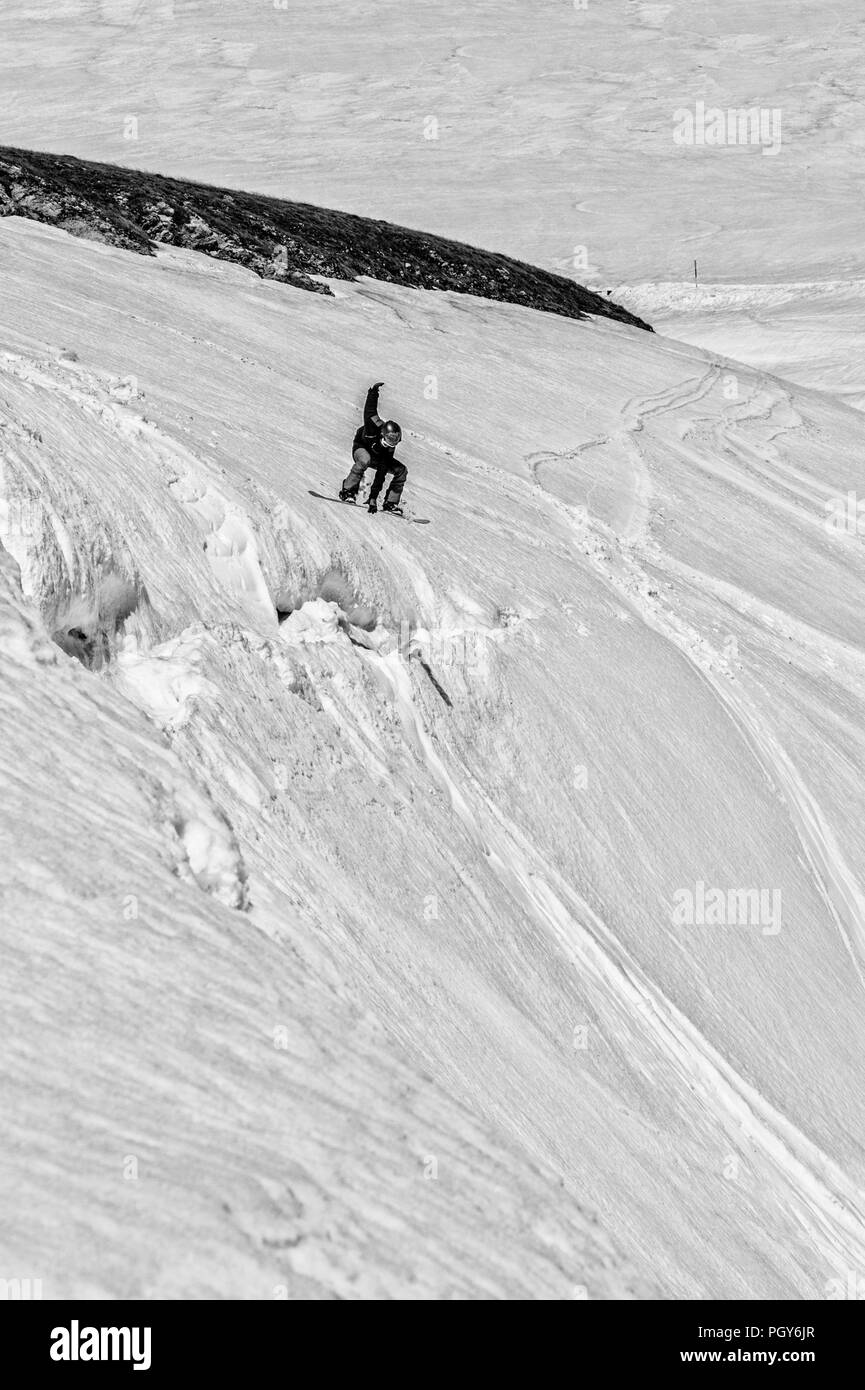 Un snowboarder freeride sauter d'une falaise et fait son truc Banque D'Images