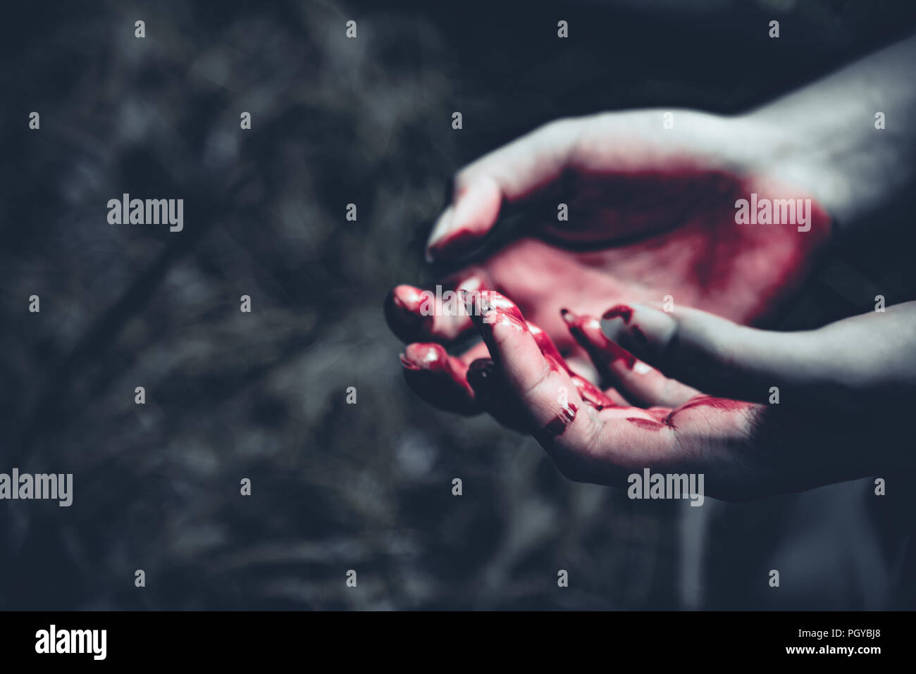 Close up of bloody hands en forêt sombre arrière-plan. L'horreur et le concept de Ghost. Meurtre et criminel concept. Journée de l'Halloween et le sacrifice thème. Un peuple Banque D'Images
