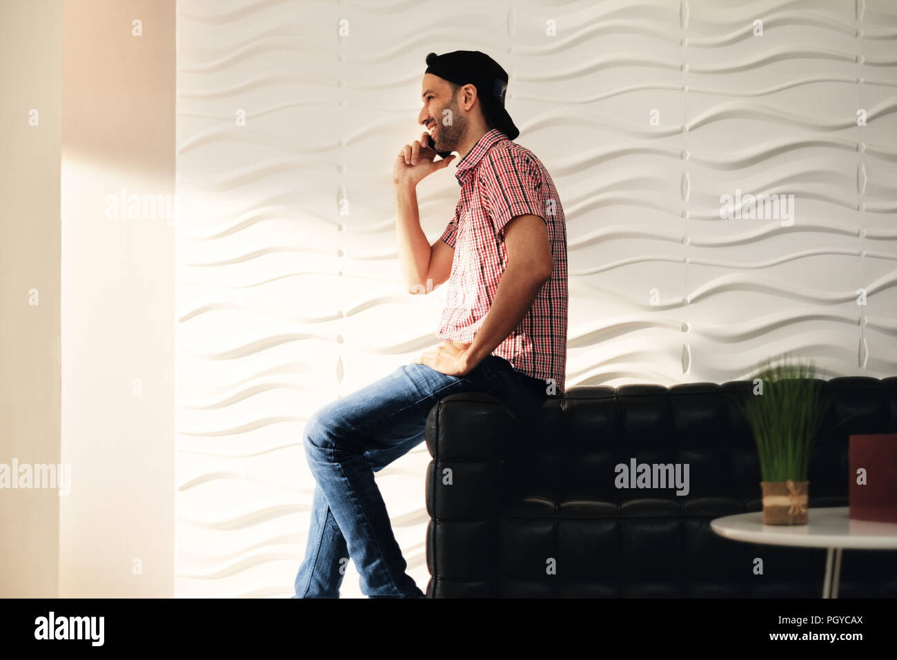 Jeune Latino Man Talking On Cell Phone At Home Banque D'Images