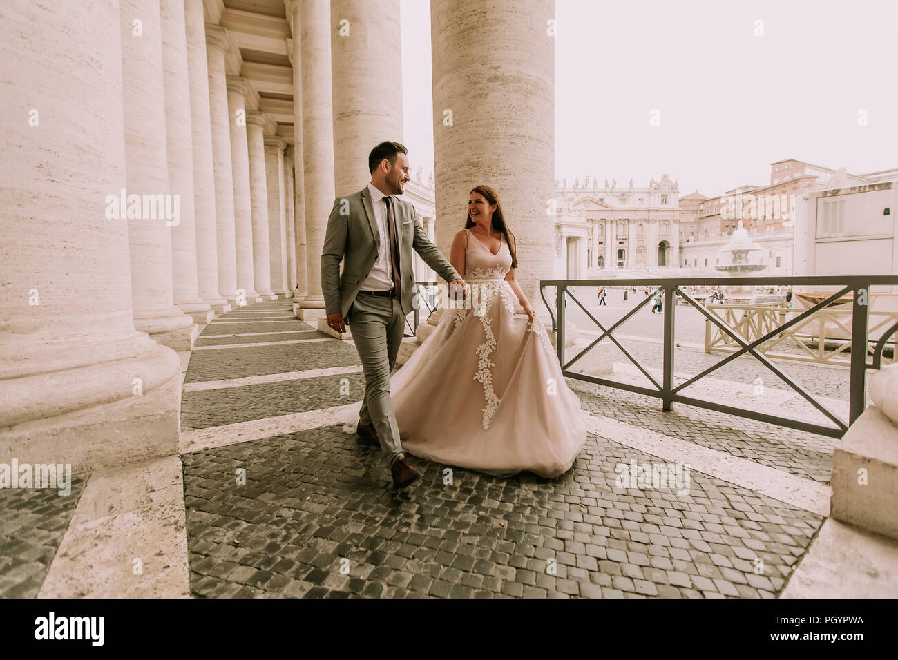 Jolie jeune femme en robe de mariée dans la colonnade du Vatican Banque D'Images