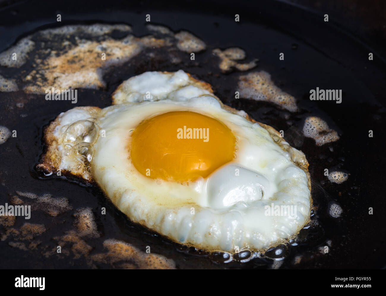 Un œuf frites dans le beurre dans une casserole en acier au carbone Banque D'Images