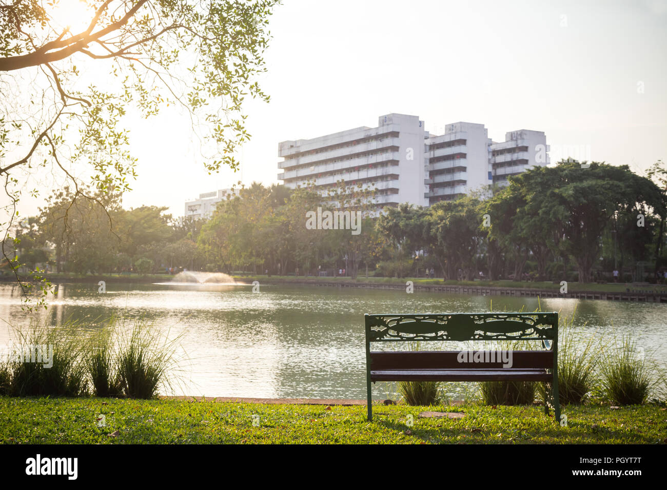 Banc de parc vide dans le jardin avec vue sur le lac et de vacances dans le parc de la ville au matin avec sunbeam. arbre vert et beau lac est une bonne qualité Banque D'Images