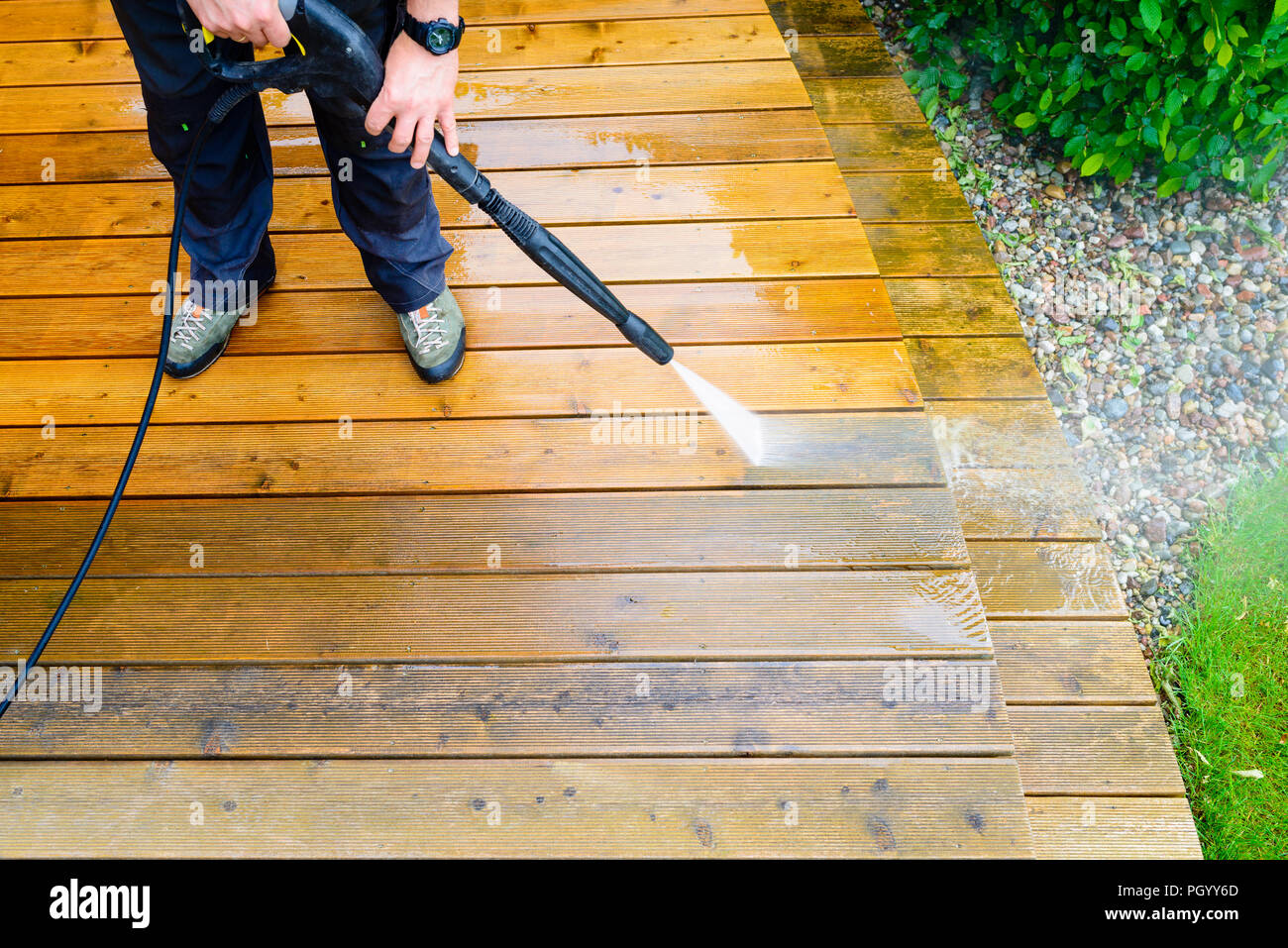 Terrasse nettoyage avec une rondelle de puissance - haute pression de l'eau  de nettoyage sur la surface de terrasse en bois Photo Stock - Alamy