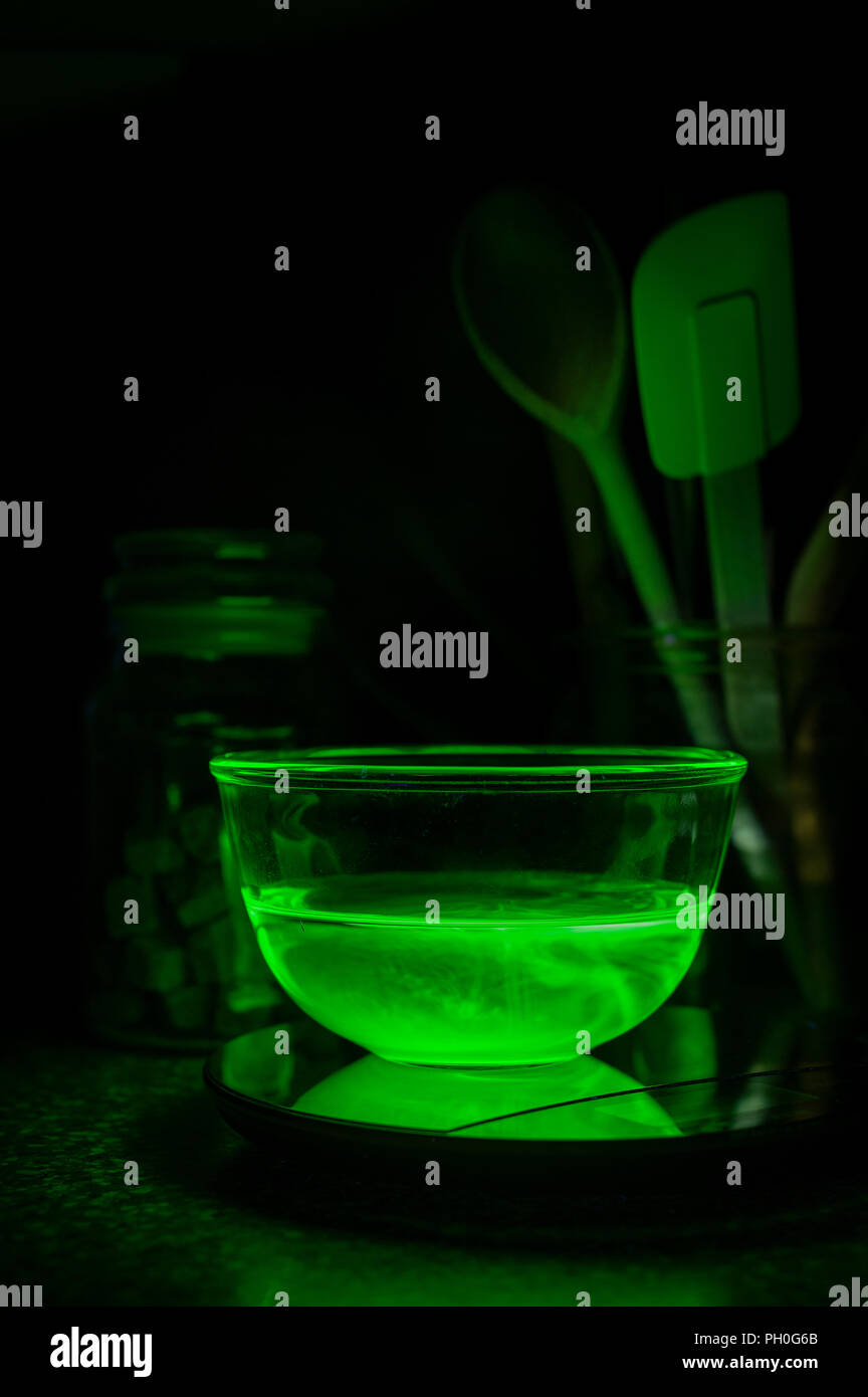 La cuisson à l'eau, chimie bol rempli illuminée par la lumière UV avec pigment fluorescent, incandescent éclairage étrange off rayonnant dans les matières radioactives Banque D'Images