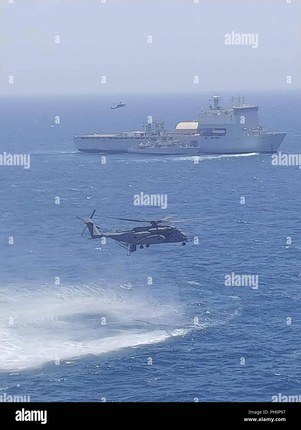 U.S. 5ÈME ZONE DES OPÉRATIONS DE LA FLOTTE (17 juin 2018) Un hélicoptère MH-53 Sea Dragon, attribué à 'la' Blackhawks de l'Escadron d'hélicoptères de la lutte contre les mines (HM), 15 téléskis un AQS-24B comme système de chasse aux mines destiné au chasseur de la Royal Navy HMS Middleton (M34) aux côtés de radeaux Royal Fleet Auxiliary landing ship dock de demandes La Baie de Cardigan (L3009) alors qu'un MH-60 Sea Hawk, affecté à l'Escadron d'hélicoptères de combat de la mer (HSC), repart avec 26 visiteurs distingués au cours de l'exercice de lutte contre les mines (MCMEX) 18-2. L'exercice bilatéral de coopération mutuelle, améliore les capacités de lutte contre les mines et configurations spécialement conçues Banque D'Images