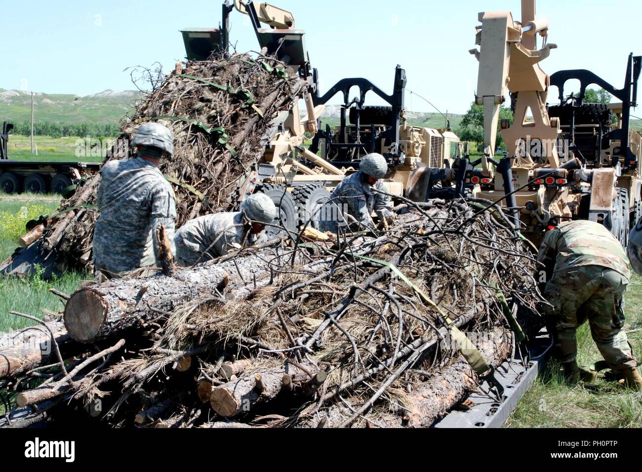 Les soldats de la 137e compagnie de transport, Kansas Army National Guard, desserrer les sangles sur une charge de bois à Red Shirt, S.D., 15 juin 2018. Le M1057 A1 Système de chargement palettisé porte le bois de Custer, S.D., à des réserves au cours de l'opération annuelle de bois courriers dans le cadre de l'exercice d'entraînement de Coyote d'or. Banque D'Images