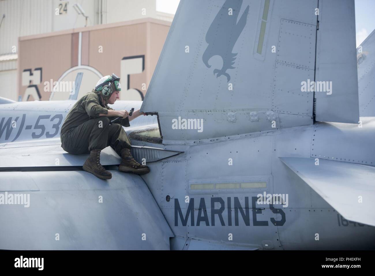 Un Marine U.S. Marine avec l'Escadron d'attaque de chasseurs tout temps 533 s'occupe de l'entretien d'un F/A-18 Hornet, Marine Corps Air Station La Baie de Kaneohe, Hawaii (Base du Corps des Marines MCBH), 22 juin 2018. L'escadron est en ce moment à bord MCBH pour soutenir l'exercice Rim of the Pacific en 2018. Banque D'Images