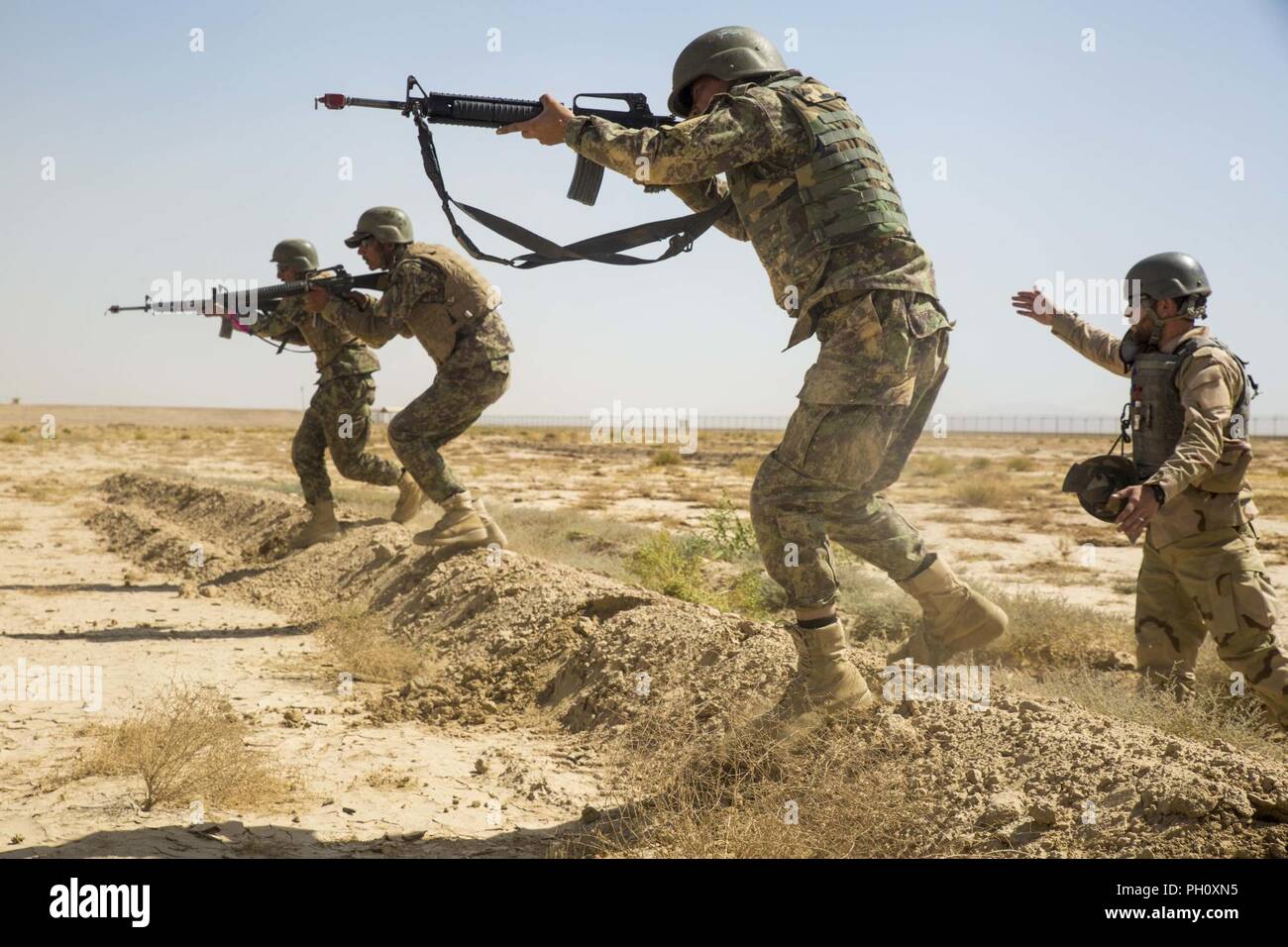 La province d'Helmand, en Afghanistan (20 juin 2018) - L'Armée nationale afghane (ANA) 215e soldats Corps lié à un squad vers un ennemi fictif pendant une gamme au Camp Shorabak. Les soldats de l'ANA ont mené des attaques escouade lors d'un exercice d'entraînement dans le cadre du cycle de préparation opérationnelle, qui est un segment de formation visant à améliorer les compétences de l'infanterie Des soldats de l'ANA et de renforcer l'efficacité de l'unité globale. Banque D'Images