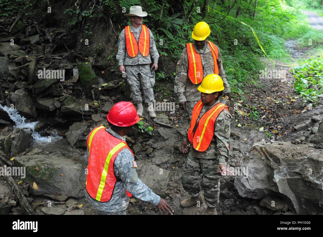 Le s.. Gideon Hurtault, ingénieur 662nd Assistance Entreprise, explique au commandant du bataillon, le Major Nina Clarke-Brewley le travail de son équipe a fait pour remplacer un ponceau au Camp Dawson, West Virginia, le 21 juin. Le personnel de commandement des troupes 104e et la garde nationale Chef d'état-major le colonel Shawn Harris a visité l'entreprise alors qu'il sur la formation annuelle. Banque D'Images