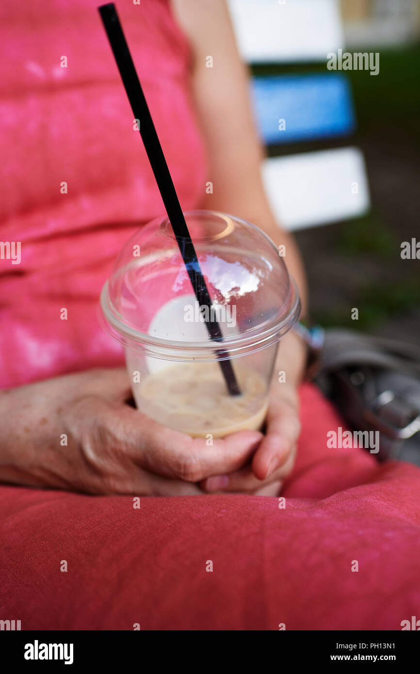 Femme adulte à l'aide du smartphone sur le banc Banque D'Images