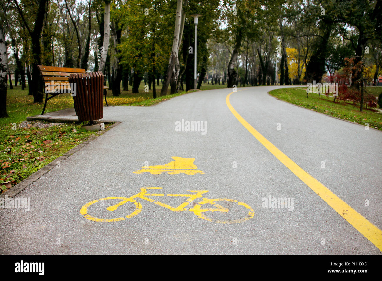 Signe du vélo et roller track sur l'asphalte. Une partie de la piste d'arrière-plan pour le roller et le vélo avec une enseigne peinte. Le parc en automne Banque D'Images