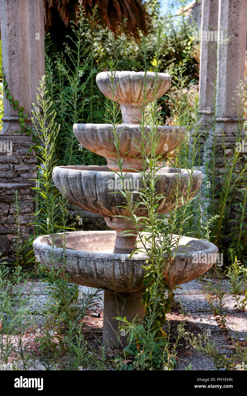 Une fontaine décorative en pierre. Ancien vintage rustique en pierre décorative  fontaine dans le jardin abandonné plein de végétation des plantes Photo  Stock - Alamy