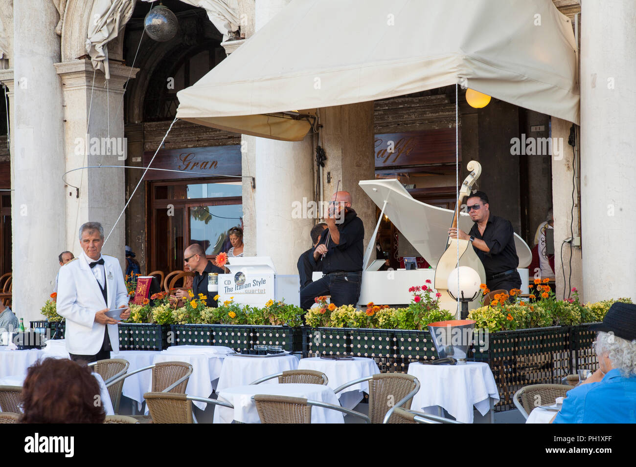 Les gens écouter de la musique classique au Grand Café de Chioggia, la Piazza San Marco, Venice, Veneto, Italie tout en profitant des boissons. Performance en direct de l'italien Banque D'Images