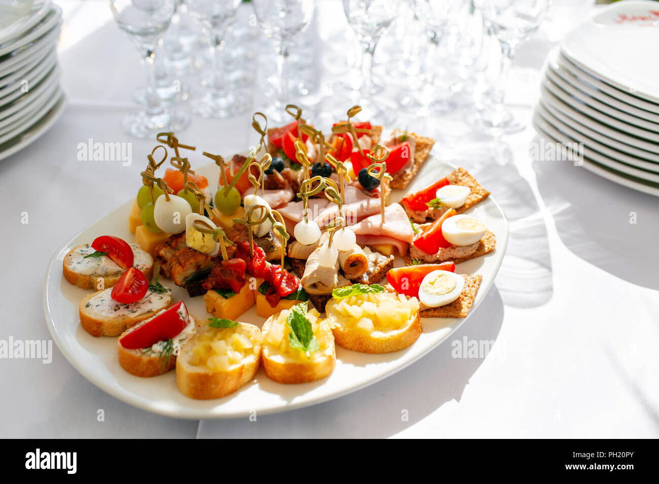 Banquet solennel. Beaucoup de verres de champagne ou de vin sur la table dans un restaurant. table de buffet avec plein de délicieux en-cas. canapes, bruschetta, et peu de desserts sur plaque de bois board Banque D'Images