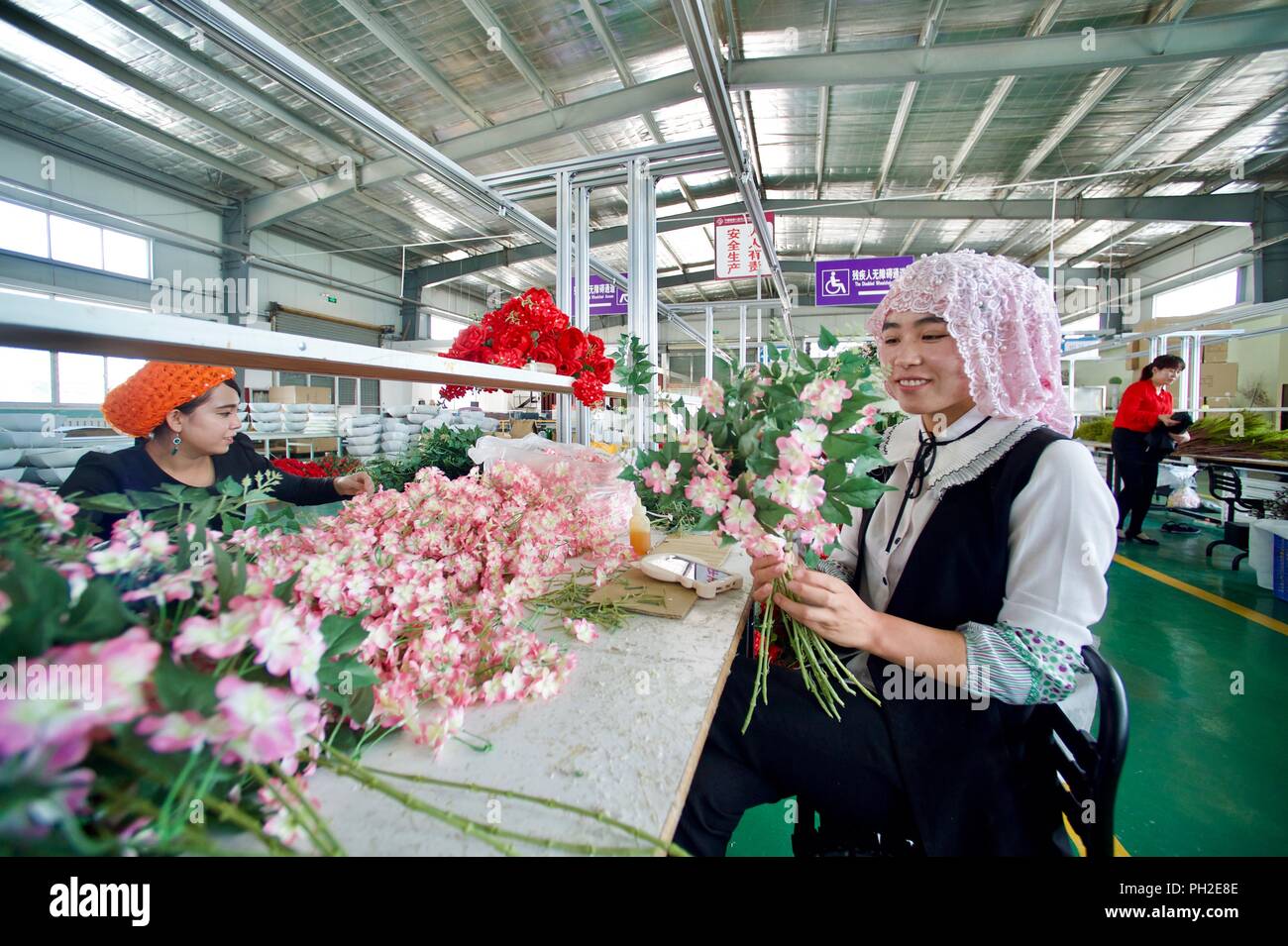 (180830) -- GUYUAN, 30 août 2018 (Xinhua) -- Les ouvriers effectuent des fleurs artificielles lors d'un atelier dans le nord-ouest de la Chine, du comté de Longde Ningxia Hui la région autonome, le 29 août 2018. L'entreprise de faire des fleurs artificielles a été introduit à partir du sud-est de la province de Fujian en Chine en 2013. Les produits sont principalement exportés vers l'Europe, Moyen-Orient, et Asie du sud-est, en aidant les villageois de se débarrasser de la pauvreté. (Xinhua/Jiang Kehong)(gxn) Banque D'Images